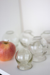 Glass jars for hijama and apple on a white background. Bloodletting. Sunnah treatment. Islam.