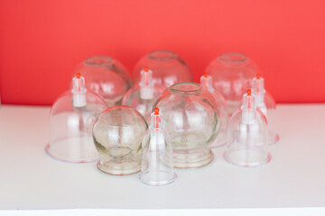 Glass jars for hijama and an apple on a red background. Bloodletting. Sunnah treatment. Islam.