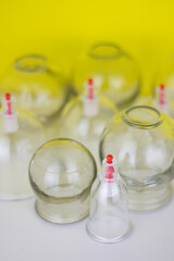 Glass jars for hijama and an apple on a yellow background. Bloodletting. Sunnah treatment. Islam.