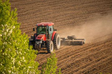 Obraz premium Farming Frontier: Tractor Tilling the Earth