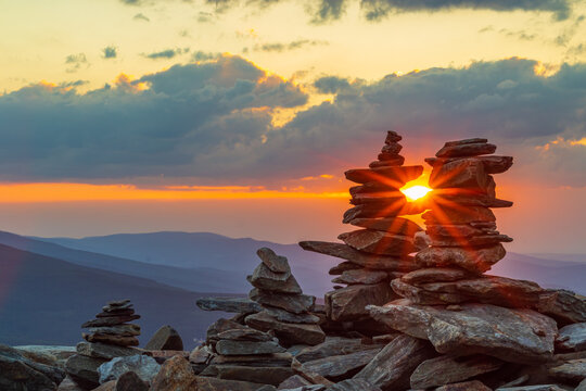 Kamienne kopczyki o zachodzie słońca (Skalny St&oacute;ł) w lato z widokiem na Śnieżkę i całe Karkonosze	