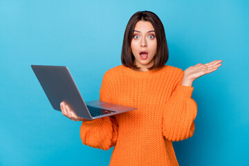 Portrait of attractive amazed clueless girl using laptop new web offer isolated over bright blue...