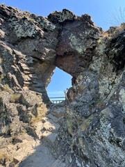 Hole in a rock formation with blue sky in the background
