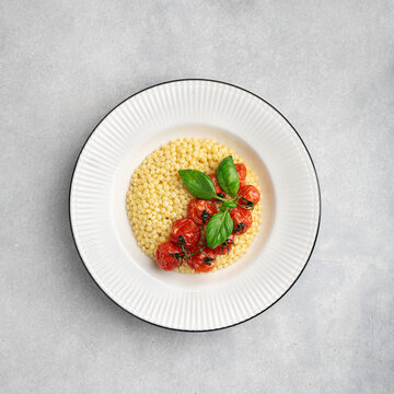 Pasta ptitim in a white plate, top view