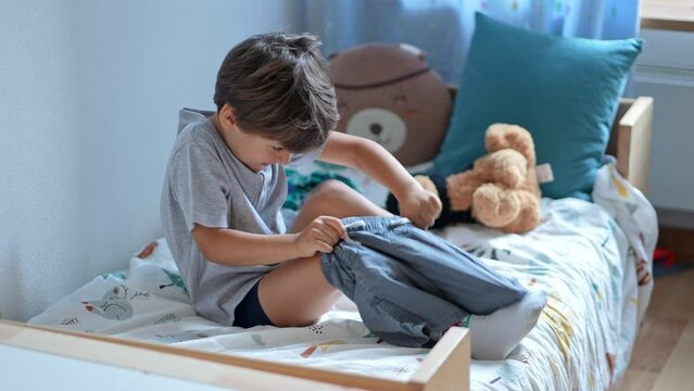 Getting Ready To Go - Young Boy Dresses In Shorts For Outing. Child Clothing Himself In The Morning Daily Routine