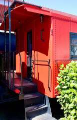 bright red old fashioned caboose at the train station