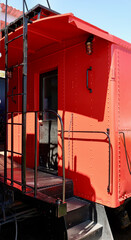 old fashioned bright red caboose at the train station