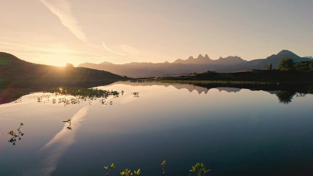 Sunrise shines over Lac Guichard with Arves massif and lake reflection in autumn at Aiguilles d'Arves, French Alps, France