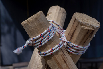 Bound unity. Timber  tied with rope knot. Black sheet as background. Sunny day. We got each other,...