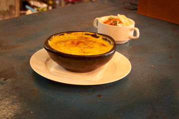Corn cake, typical Chilean dish in gourmet presentation served on a cooked clay saucer and...