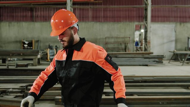 Caucasian factory worker take the piece of metal and start to measure the metal in the manufacturing industrial factory