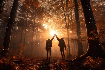 Two individuals standing in a forest with their hands raised
