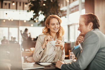Businessman and businesswoman having a meeting at an indoor cafe