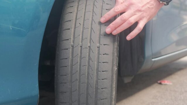 The finger indicates damage to the tire tread. Tire tread problems due to incorrect tire pressure. Worn out old tire.