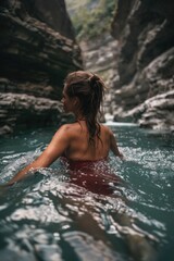 A woman in a red bikini enjoying a swim in a river. Ideal for travel and summer vacation concepts