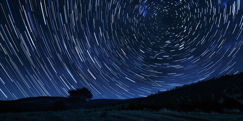 Fototapeta premium Circular Star Trails Above Serene Night Landscape