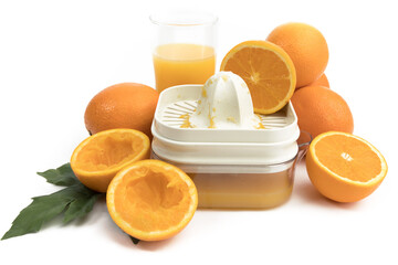 an orange juicer with a glass of fresh squeezed orange juice and oranges isolated on white
