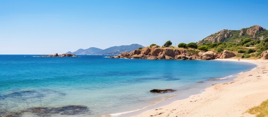 Obraz premium Scenic beach view with rocky cliff and clear water
