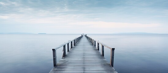 Wooden jetty in the sea with distant boat - obrazy, fototapety, plakaty