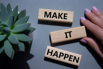 Make it Happen symbol. Concept words Make it Happen on wooden blocks. Beautiful grey background...