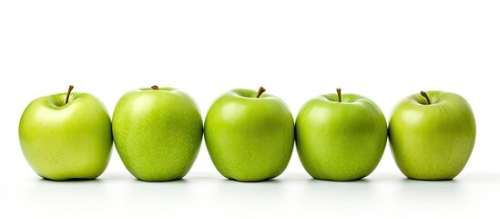 Four ripe apples in a line on a white surface - Powered by Adobe