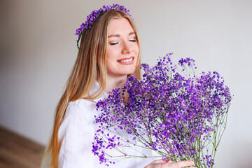 girl with a bouquet of lilac gypsophila flowers and a wreath on her head