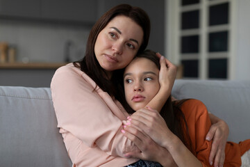 Empathic mom embracing calming down upset teen daughter helping and supporting, mother comforting and consoling girl