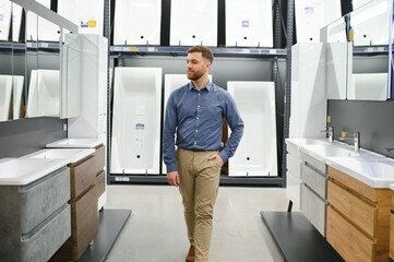 Man choosing new bathroom furniture at the plumbing shop with lots of sanitary goods