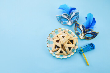 Jewish holiday Purim background with hamantaschen or hamans ears cookies, carnival mask and noisemaker - 765199143