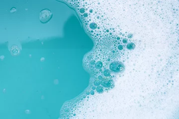 Poster Detergent foam bubble on water. Blue background, Soap sud © Bowonpat