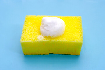Cleaning sponge with foam of dishwashing liquid. Washing dishes concept