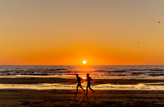 two runners against the background of the setting sun