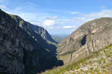 Obraz premium Huge canyon formed by very high vertical walls, inside it runs a river that forms some waterfalls. It is located in Serra do Cipó, Brazil