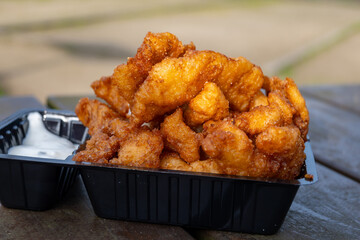 Outdoor eating of diep-fried cod fish pieces served with remoulade sauce, Dutch street food