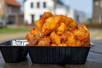 Outdoor eating of diep-fried cod fish pieces served with remoulade sauce, Dutch street food