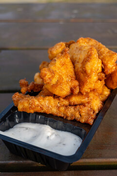 Outdoor eating of diep-fried cod fish pieces served with remoulade sauce, Dutch street food