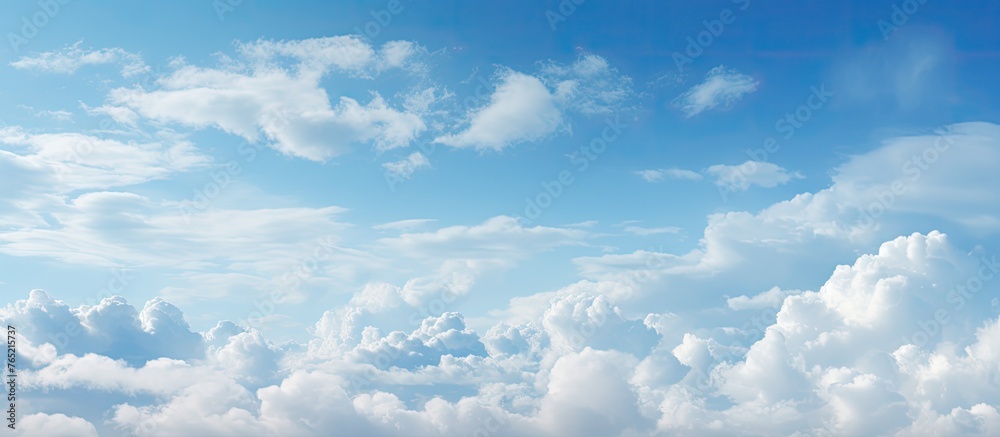 Wall mural an aircraft is flying in the sky with fluffy clouds in the background
