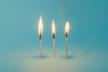 Three lit matches on a blue background