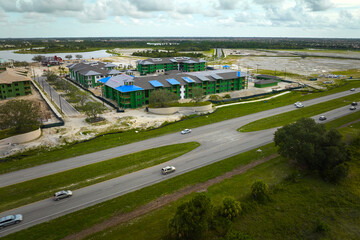 Top view of apartment buildings under construction in developing suburban area near transport infrastructure. Development of residential housing in american suburbs. Real estate market in the USA
