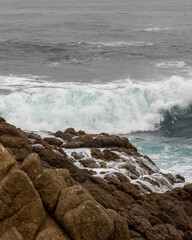 Beach waves at sunrise sunset over rocks on the coastline beach