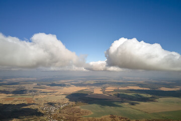 Aerial view at high altitude of earth covered with puffy cumulus clouds forming before rainstorm