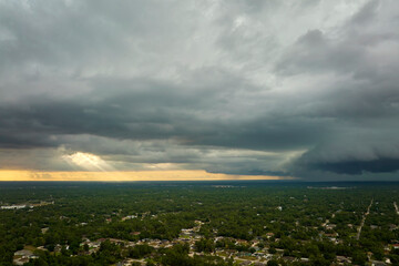 Landscape of dark ominous clouds forming on stormy sky before heavy thunderstorm over rural town area