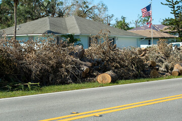 Piles of tree rubbish on road side for recovery truck pickup after hurricane in Florida residential...