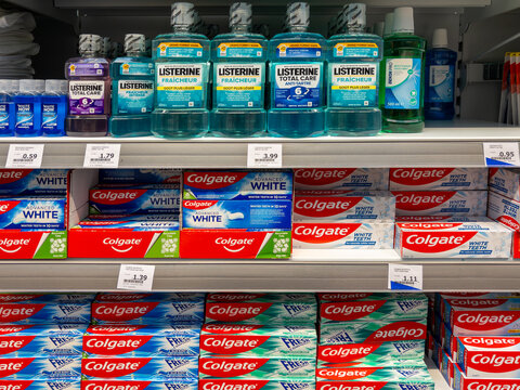 Italy - March 20, 2024: Listerine mouthwash bottles and colgate toothpaste packs displayed on shelves for sale in Italian supermarket