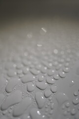 close up of water droplets on white background, macro photography, shallow depth of field, blurry background, water drops