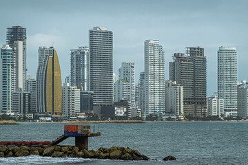 Cartagena, Colombia - July 25, 2023: Seen from where Calle 31 meets Avenida Santander, breakwater and Tall buildings skyline on north sea side of Bocagrande peninsula. - obrazy, fototapety, plakaty