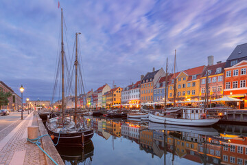 Fototapeta na wymiar Nyhavn with colorful facades of old houses and ships in Old Town of Copenhagen, capital of Denmark.