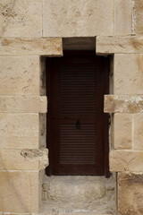 Fototapeta na wymiar Dark brown door in in white stone wall Lagos