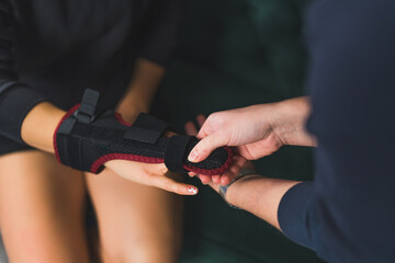 a person wrapping a splint on the other person's middle finger at home. High quality photo