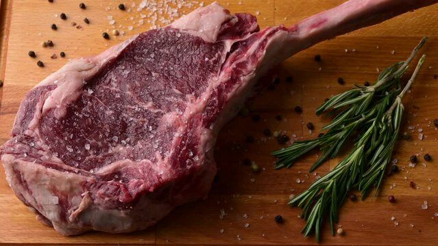 fresh tomahawk steak on rustic board